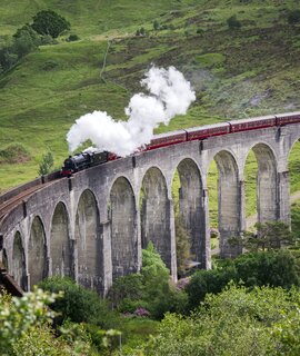 Dampfzug faehrt ueber das Glenfinnan-Viadukt in Schottland | © Gettyimages.com/wanderluster
