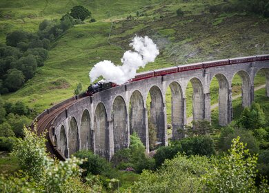 Harry Potter Zug in Schottland | © Gettyimages.com/wanderluster Dampfzug faehrt ueber das Glenfinnan-Viadukt in Schottland | © Gettyimages.com/wanderluster