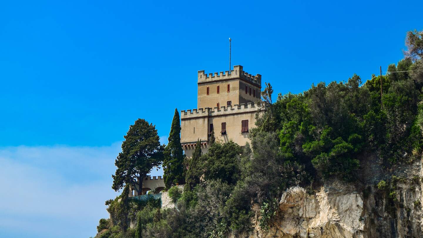 Stadtturm auf einer Klippe in der Nähe des Mittelmeers in Finale Ligure an der Riviera in Italien | © Gettyimages.com/Jana_Janina