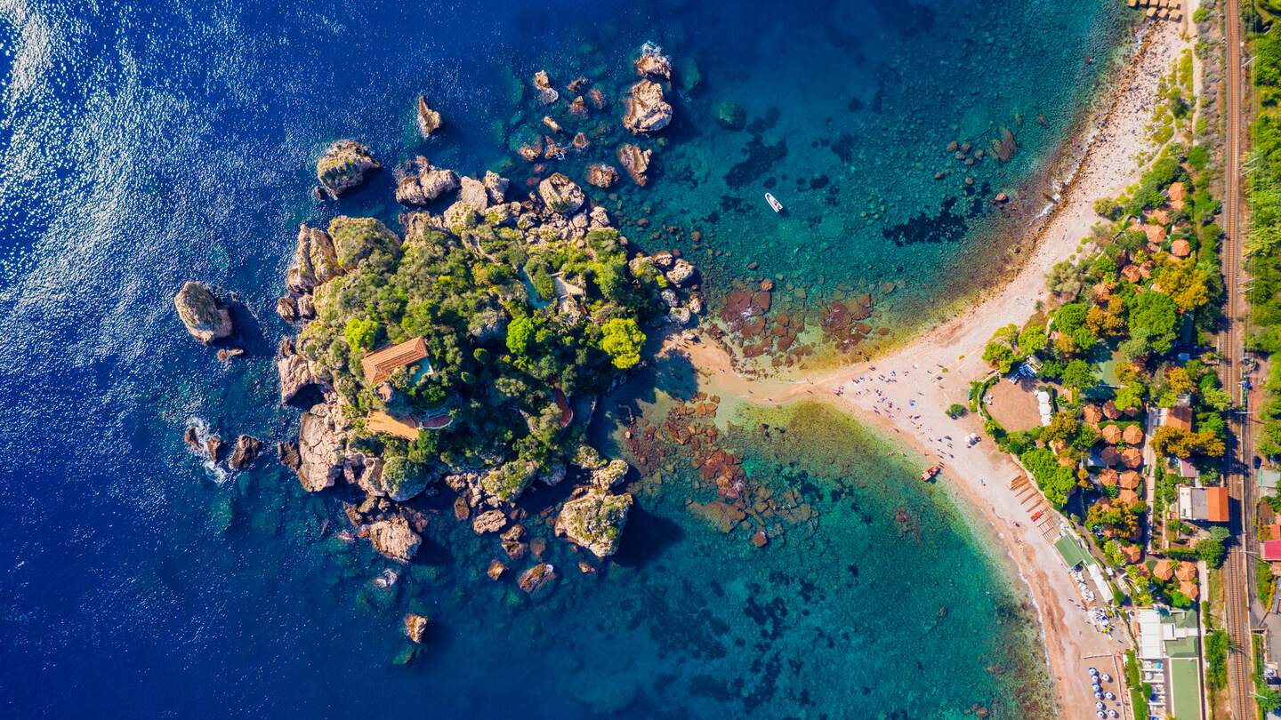 Luftaufnahme der Isola Bella in Taormina, Sizilien, Italien. Isola Bella ist eine kleine Insel in der Nähe von Taormina, Sizilien, Italien. Schmaler Pfad verbindet Insel mit Festland Taormina Strand in azurblauen Gewässern des Ionischen Meeres | © Gettyimages.com/daliu
