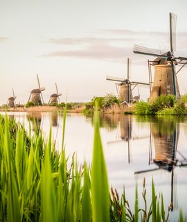 Ein Langzeitbild von altmodischen niederländischen Windmühlen an einem Kanal in der Nähe des Dorfes Kinderdijk in Holland | © Gettyimages.com/georgeclerk