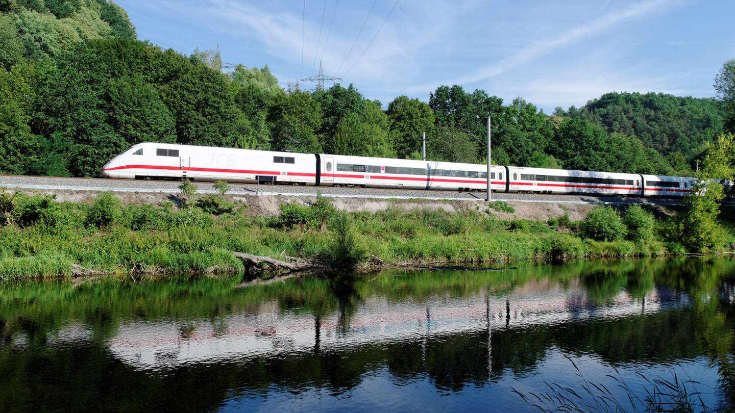 Spiegelbild der Geschwindigkeit | ©  Deutsche Bahn AG Hochgeschwindigkeitszug mit roten,der entlang von Gleisen neben einem Gewässer fährt.  | ©  Deutsche Bahn AG
