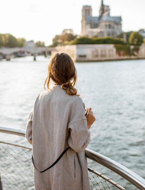 Frau geniesst Flusskreuzfahrt | © Gettyimages.com/RossHelen Frau geniesst den Landschaftsblick auf die Stadt Paris vom Boot aus | © Gettyimages.com/RossHelen