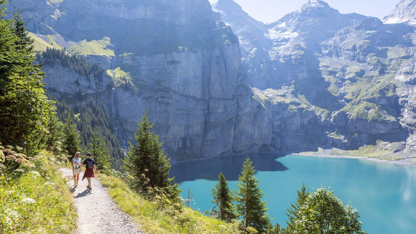 Wanderer am Bergsee | © Gettyimages.com/Mystockimages Zwei Personen wandern im Sommer in einer wunderschoenen Alpenlandschaft in den Schweizer Alpen | © Gettyimages.com/Mystockimages