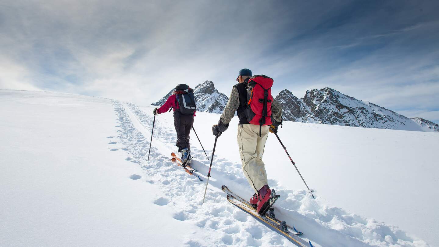 Alpine Skifahrer | © gettyimages.com/michelangeloop Zwei aeltere Alpinskifahrer steigen auf Skier  | © gettyimages.com/michelangeloop