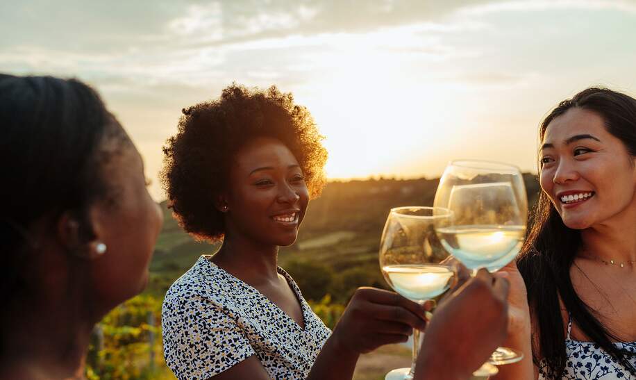 Stoss auf die Freundschaft | © Gettyimages.com/Dimensions Drei Maedchen mit Glaesern Weisswein stossen auf die Freundschaft an | © Gettyimages.com/Dimensions