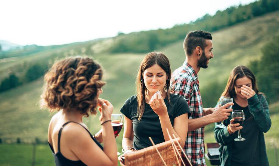 Freunde stoßen beim Picknick an  | © Gettyimages.com/franckreporter